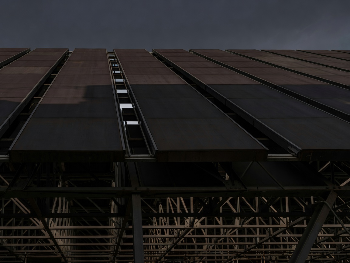 Roof panels aligned over a dark steel truss system, emphasizing the direction of travel