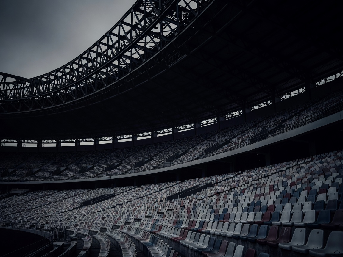 Stadium seating beneath a shadowed roof truss system
